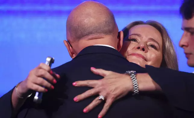 Australian Liberal Party leader Peter Dutton embraced by his wife Kirilly after making a concession speech following the general election in Brisbane, Australia, Saturday, May 3, 2025. (AP Photo/Pat Hoelscher)