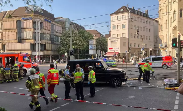 Emergency personnel work at the scene where a vehicle collided into a group of people in Stuttgart, Germany, on Friday, May 2, 2025. (Marco Krefting/dpa via AP)
