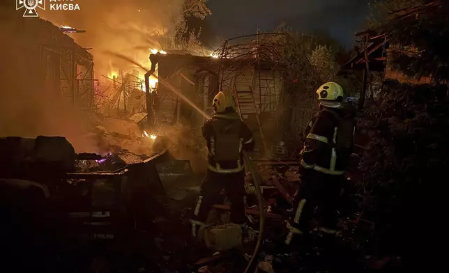 In this photo provided by the Ukrainian Emergency Service, emergency services personnel work to extinguish a fire following a Russian attack in Kyiv, Ukraine, Sunday, May 4, 2025. (Ukrainian Emergency Service via AP)
