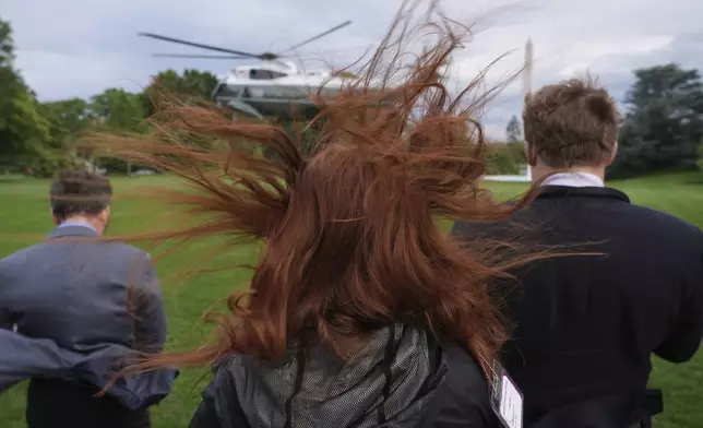 People watch as Marine One, with President Donald Trump aboard, departs the White House en route to Trump National Golf Club Washington DC for a crypto dinner, Thursday, May 22, 2025, in Washington. (AP Photo/Jacquelyn Martin)