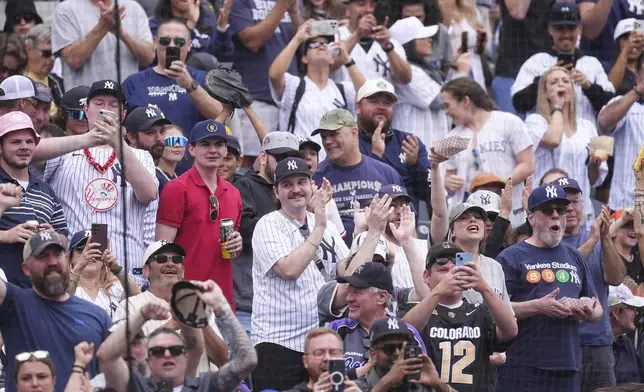 Fans applaud as New York Yankees' Aaron Judge circles the bases after hitting a solo home run off Colorado Rockies starting pitcher Kyle Freeland in the first inning of a baseball game Saturday, May 24, 2025, in Denver. (AP Photo/David Zalubowski)