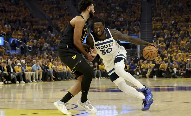 Minnesota Timberwolves forward Julius Randle (30) drives to the basket against Golden State Warriors forward Trayce Jackson-Davis, left, during the first half of Game 4 in the Western Conference semifinals of the NBA basketball playoffs Monday, May 12, 2025, in San Francisco. (AP Photo/Jed Jacobsohn)