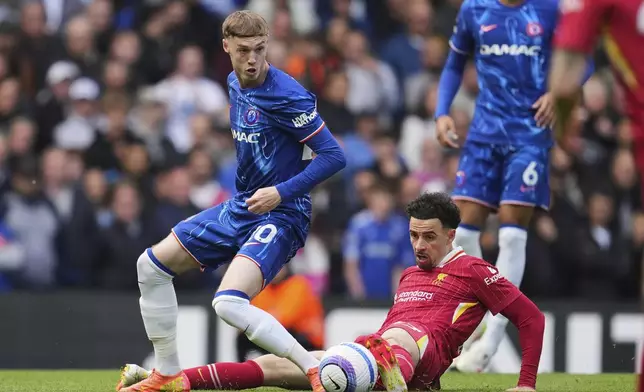 Liverpool's Curtis Jones, bottom, challenges Chelsea's Cole Palmer during the English Premier League soccer match between Chelsea and Liverpool at Stamford Bridge stadium in London, Sunday, May 4, 2025. (AP Photo/Kin Cheung)