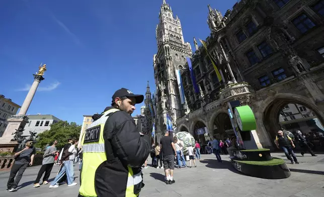 A policeman patrols in front of the Town Hall in Marienplatz, ahead of the Champions League final soccer match between Paris Saint-Germain and Inter Milan in Munich, Germany, Friday, May 30, 2025. (AP Photo/Luca Bruno)