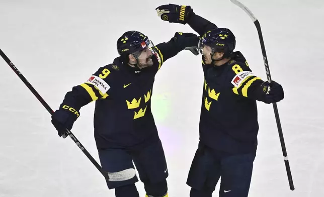Sweden's Jonas Brodin, right, celebrates scoring with teammate Filip Forsberg during the IIHF Ice Hockey World Championship group A match between Sweden and Austria at Avicii Arena in Stockholm, Sweden, Saturday May 10, 2025. (Christine Olsson/TT via AP)