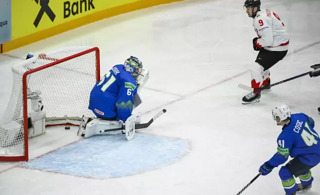 Canada's Nate MacKinnon, top, scores during the IIHF Ice Hockey World Championship group A match between Slovenia and Canada at Avicii Arena in Stockholm, Sweden, Saturday May 10, 2025. (Fredrik Sandberg/TT News Agency via AP)