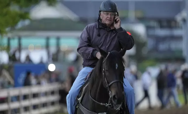 CORRECTS ID TO BILL MOTT NOT MARK CASSE Kentucky Derby trainer Bill Mott rides to his barn after watching a workout at Churchill Downs, Monday, April 28, 2025, in Louisville, Ky. (AP Photo/Charlie Riedel)