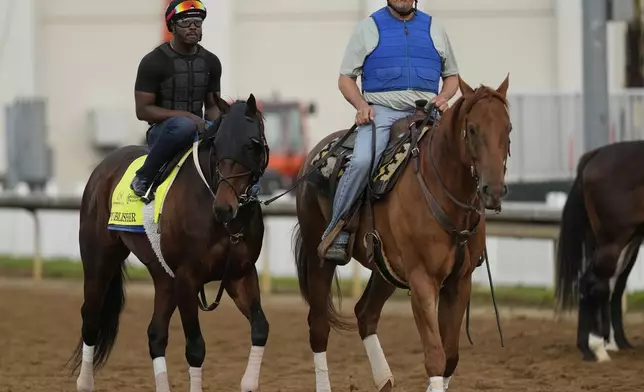 Kentucky Derby entrant Publisher is led on the track by trainer Steve Asmussen during a workout at Churchill Downs Tuesday, April 29, 2025, in Louisville, Ky. (AP Photo/Charlie Riedel)