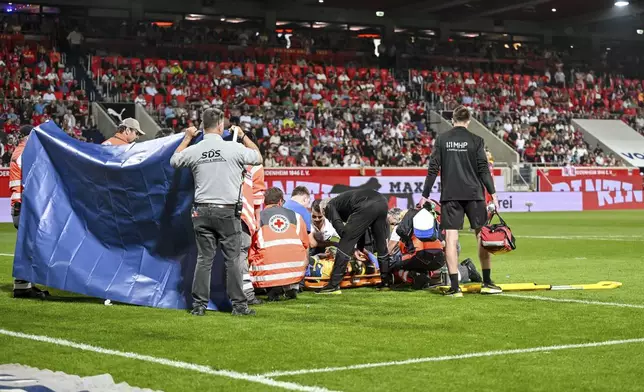 Heidenheim goalkeeper Kevin Müller is treated on the pitch for an injurey during the Bundesliga soccer match between FC Heidenheim and VfL Bochum at Voith-Arena. Heidenheim, Germany, Friday May 2, 2025. (Harry Langer/dpa via AP)