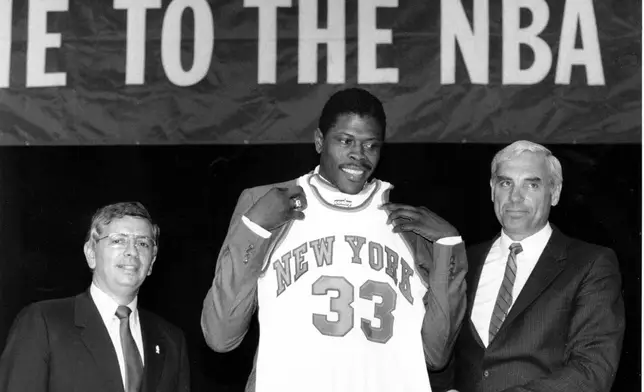 FILE - In this June 18, 1985, file photo, Patrick Ewing accepts his New York Knicks jersey from Dave DeBusschere, right, general manager of the Knicks, as NBA commissioner David Stern look on, at the NBA Draft in New York. (AP Photo/Marty Lederhandler, File)