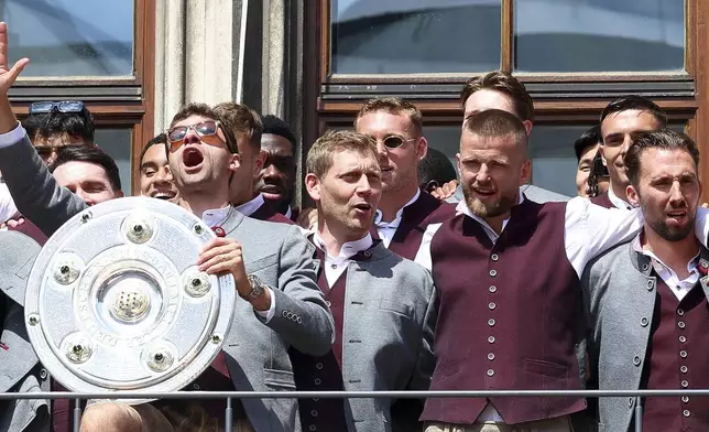 Bayern's Thomas Mueller, center left, celebrates with the championship trophy next to his teammates on the town hall balcony in Munich, Germany, Sunday, May 18, 2025. (Daniel Loeb/dpa via AP)