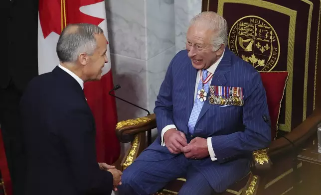 Canada Prime Minister Mark Carney, left, and King Charles talk ahead of the King delivering speech from the throne in the Senate in Ottawa, Canada on Tuesday, May 27, 2025. (Sean Kilpatrick/The Canadian Press via AP)