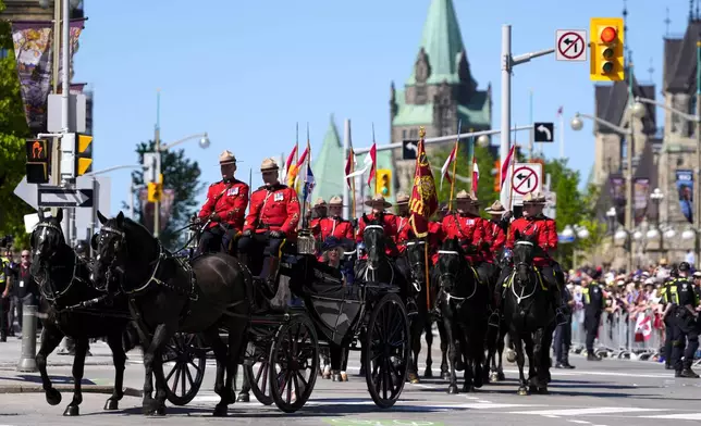 King Charles and Queen Camilla arrive by horse-drawn landau at the Senate of Canada building in Ottawa, Canada, during a royal visit on Tuesday, May 27, 2025. (Justin Tang/The Canadian Press via AP)