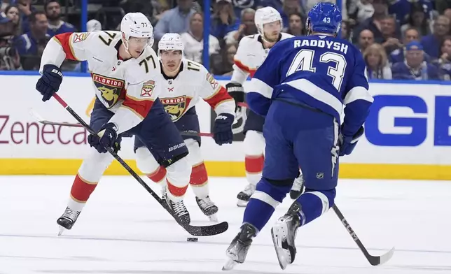 Florida Panthers defenseman Niko Mikkola (77) carries the puck against Tampa Bay Lightning defenseman Darren Raddysh (43) during the first period in Game 5 of an NHL hockey Stanley Cup first-round playoff series, Wednesday, April 30, 2025, in Tampa, Fla. (AP Photo/Chris O'Meara)