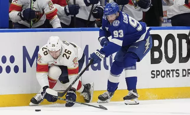 Tampa Bay Lightning center Gage Goncalves (93) takes down Florida Panthers defenseman Uvis Balinskis (26) during the first period in Game 5 of an NHL hockey Stanley Cup first-round playoff series, Wednesday, April 30, 2025, in Tampa, Fla. (AP Photo/Chris O'Meara)