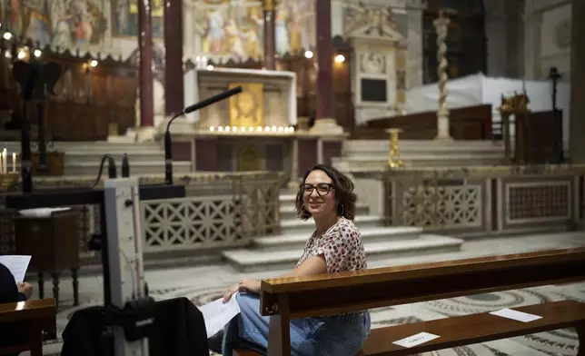 Lisa Remondino, chorus director, poses for a photo before the start of a mass in Santa Maria in Trastevere church in central Rome, Sunday, May 4, 2025. (AP Photo/Alessandra Tarantino)