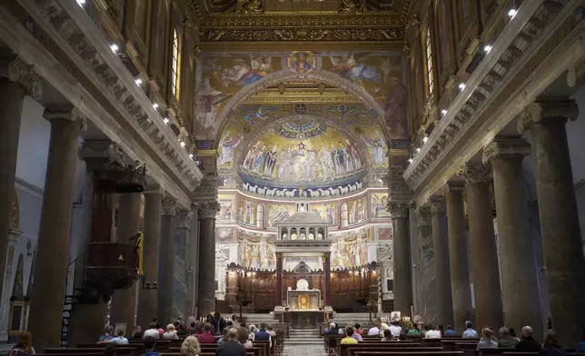 People attends a mass in Santa Maria in Trastevere church in central Rome, Sunday, May 4, 2025. (AP Photo/Alessandra Tarantino)