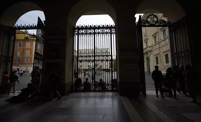 People enter Santa Maria in Trastevere church in central Rome, Sunday, May 4, 2025. (AP Photo/Alessandra Tarantino)