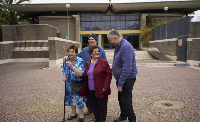Father Roberto Cassano, right, shares a word with his parishioners Ida Di Giovannantonio, Maddalena Rughetti and Gavio Iachini, after a mass in San Paolo Della Croce parish church in Corviale neighbourhood, in Rome, Sunday, May 4, 2025. (AP Photo/Alessandra Tarantino)