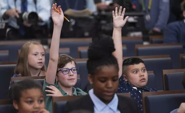 Children raise their hands as White House press secretary Karoline Leavitt speaks during a briefing for "Take Our Sons and Daughters To Work Day" at the White House, Tuesday, May 20, 2025, in Washington. (AP Photo/Evan Vucci)