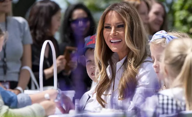 First lady Melania Trump participates in flag decorating during a Take Our Child to Work Day event in the Jacqueline Kennedy Garden at the White House, Tuesday, May 20, 2025, in Washington. (AP Photo/Alex Brandon)