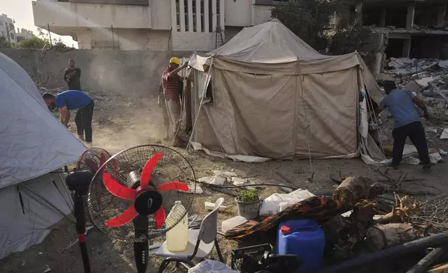 Members of the Abu Jarad family, who were displaced by the Israeli air and ground offensive in the Gaza Strip, build a new tent in Gaza City, Monday, May 19, 2025. (AP Photo/Jehad Alshrafi)