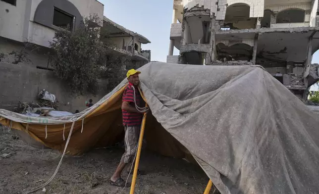Ne'man Abu Jarad sets up a new tent for his family after they were displaced by the Israeli air and ground offensive in the Gaza Strip in Gaza City, Monday, May 19, 2025. (AP Photo/Jehad Alshrafi)