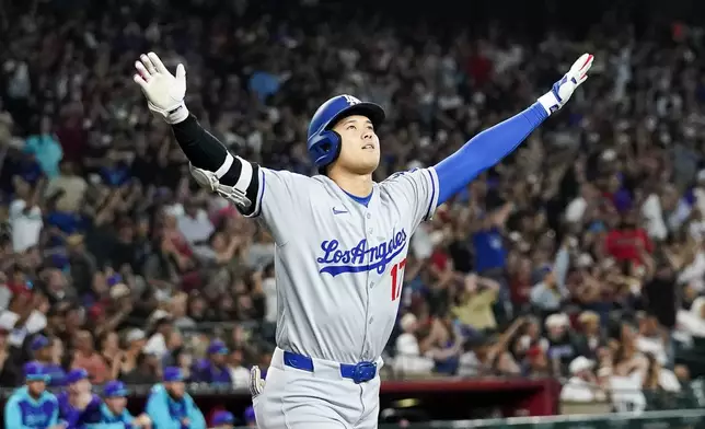 Los Angeles Dodgers' Shohei Ohtani celebrates a three run home run against for the Arizona Diamondbacks during the ninth inning of a baseball game Friday, May 9, 2025, in Phoenix. (AP Photo/Darryl Webb)