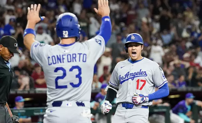 Los Angeles Dodgers' Shohei Ohtani, right, celebrates a three run home run against for the Arizona Diamondbacks during the ninth inning of a baseball game Friday, May 9, 2025, in Phoenix. (AP Photo/Darryl Webb)