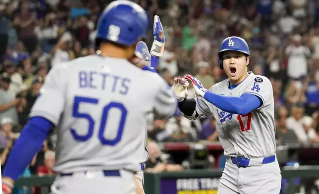 Los Angeles Dodgers' Shohei Ohtani, right, celebrates a three run home run against for the Arizona Diamondbacks during the ninth inning of a baseball game Friday, May 9, 2025, in Phoenix. (AP Photo/Darryl Webb)