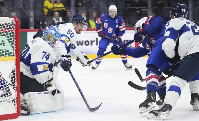 The United States' Conor Garland, second from right, scores a goal against Finland's Juuse Saros (74), Mikael Seppala (50) and Nikolas Matinpalo, right, during the second period of a quarterfinal match at the ice hockey world championships in Stockholm, Sweden, Thursday, May 22, 2025. (AP Photo/Petr David Josek)