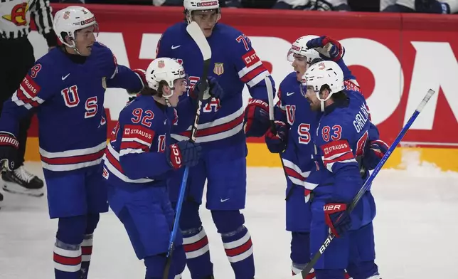 The United States' Conor Garland (83) is congratulated by teammates after scoring against Finland during the first period of a quarterfinal match at the ice hockey world championships in Stockholm, Sweden, Thursday, May 22, 2025. (AP Photo/Petr David Josek)