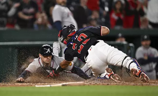 Atlanta Braves' Austin Riley is tagged out by Washington Nationals catcher Keibert Ruiz (20) as he attempts to score a run after a double hit by Matt Olson against pitcher Kyle Finnegan during the ninth inning of a baseball game in Washington, Thursday, May 22, 2025. (AP Photo/Terrance Williams)