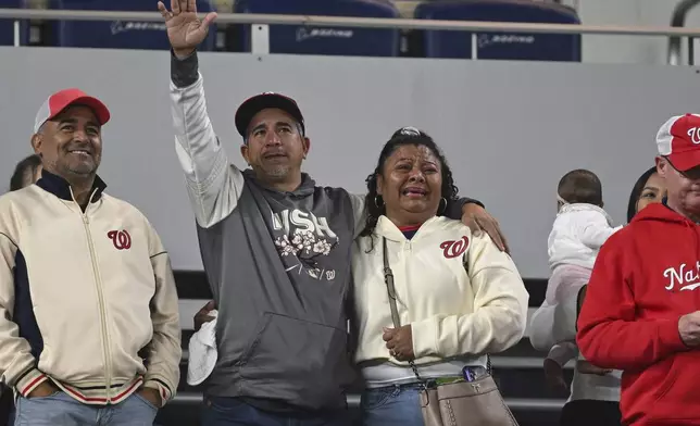 Washington Nationals' Keibert Ruiz parents acknowledge their son from the stands after a baseball game against the Atlanta Braves in Washington, Thursday, May 22, 2025. (AP Photo/Terrance Williams)