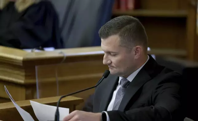 Massachusetts State Police Sgt. Yuriy Bukhenik looks over documents while testifying during the Karen Read murder trial in Norfolk Superior Court in Dedham, Mass., Friday, May 9, 2025. (Mark Stockwell/The Sun Chronicle via AP, Pool)