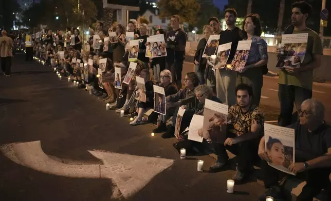 Israeli activists hold photos of Palestinian children killed during the Israel air and ground operation in the Gaza Strip, calling for an end to the war, during a protest in Tel Aviv, Israel, Saturday, May 24, 2025. (AP Photo/Leo Correa)