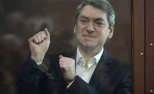 Grigory Melkonyants, co-chair of Russia's leading independent election monitoring group Golos who faces up to six years in prison, looks at the media standing in a cage in a courtroom prior to a hearing in Basmanny district court in Moscow, Russia, Wednesday, May 14, 2025. (AP Photo/Alexander Zemlianichenko)