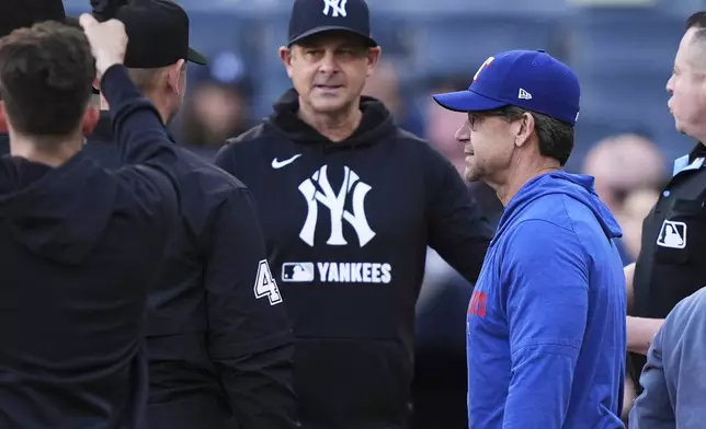 Texas Rangers hitting coach Bret Boone, right, and New York Yankees manager Aaron Boone talk to the officials before a baseball game Tuesday, May 20, 2025, in New York. (AP Photo/Frank Franklin II)