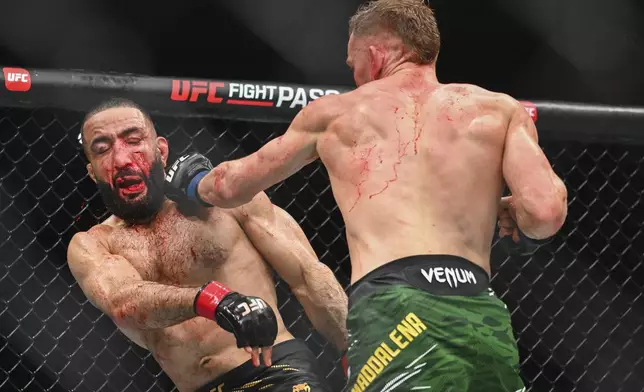 Belal Muhammad, left, takes a blow from Jack Della Maddalena during their UFC 315 mixed martial arts welterweight title bout in Montreal, Sunday, May 11, 2025. (Graham Hughes/The Canadian Press via AP)