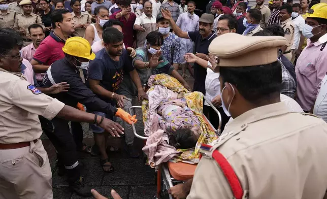A child, who was injured when a building caught fire near the Charminar area in Hyderabad, is carried by rescuers to an ambulance, India, Sunday, May 18, 2025. (AP Photo/Mahesh Kumar A.)