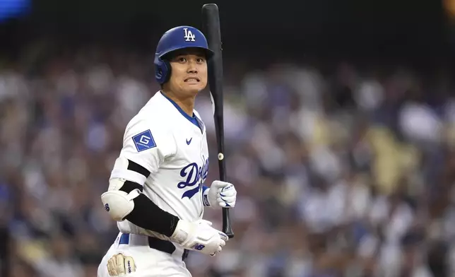 Los Angeles Dodgers' Shohei Ohtani grimaces after taking a close pitch before batting during the first inning of a baseball game against the Los Angeles Angels Friday, May 16, 2025, in Los Angeles. (AP Photo/Mark J. Terrill)