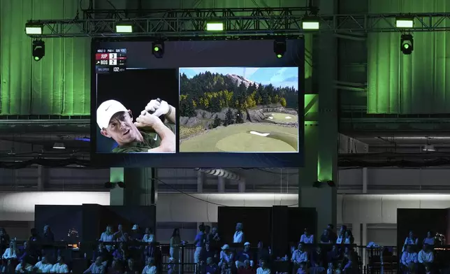 FILE - Rory McIlroy of Boston Common Golf watches a digital projection of his shot on the 13th hole during a match of the TMRW Golf League (TGL) against Jupiter Links Golf Club, Monday, Jan. 27, 2025, in Palm Beach Gardens, Fla. (AP Photo/Rebecca Blackwell, File)