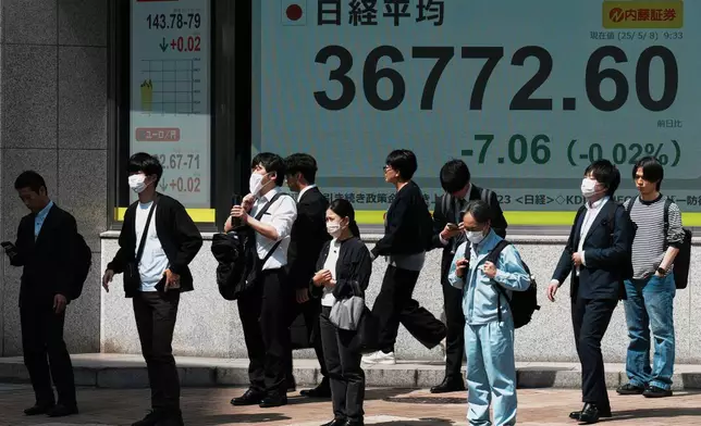 People stand in front of an electronic stock board showing Japan's Nikkei index at a securities firm Thursday, May 8, 2025, in Tokyo. (AP Photo/Eugene Hoshiko)