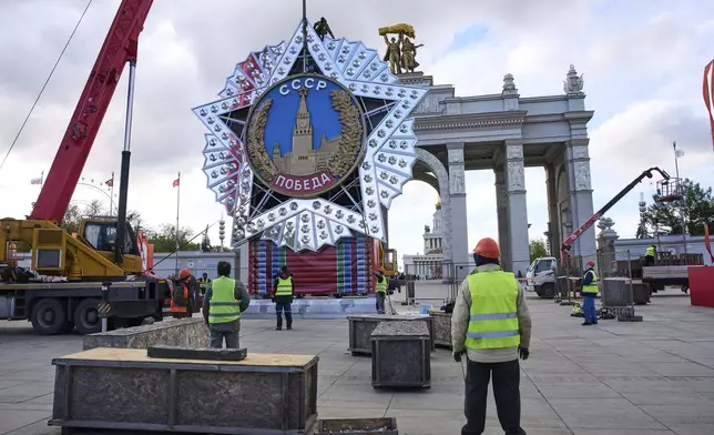 Workers assemble a model of the main Soviet order, the Order of Victory prior to Victory Day celebration in front of the historical main gates of VDNKh, The Exhibition of Achievements of National Economy in Moscow, Russia, Wednesday, April 30, 2025. (AP Photo/Alexander Zemlianichenko)