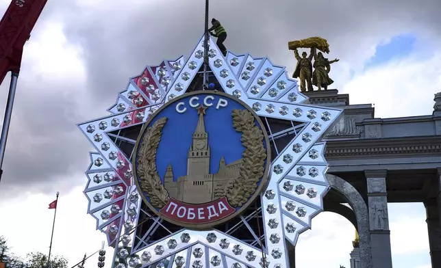 Workers assemble a model of the main Soviet order, the Order of Victory prior to Victory Day celebration in front of the historical main gates of VDNKh, The Exhibition of Achievements of National Economy in Moscow, Russia, Wednesday, April 30, 2025. (AP Photo/Alexander Zemlianichenko)