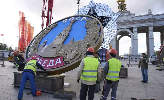Workers assemble a model of the main Soviet order, the Order of Victory prior to Victory Day celebration in front of the historical main gates of VDNKh, The Exhibition of Achievements of National Economy in Moscow, Russia, Wednesday, April 30, 2025. (AP Photo/Alexander Zemlianichenko)