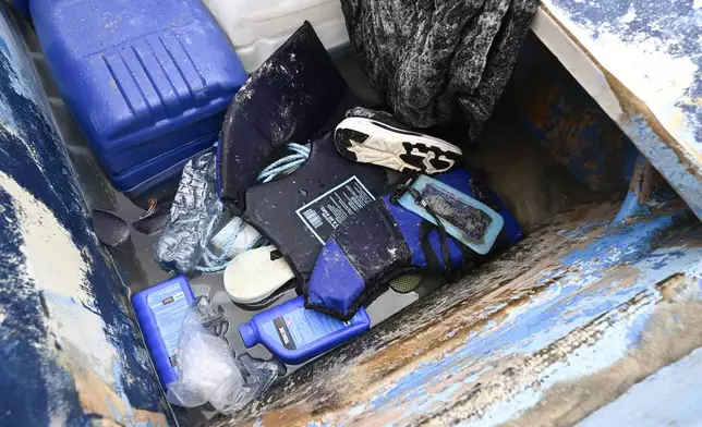 Life jackets and personal items are seen in a boat that capsized Monday, May 5, 2025, at Torrey Pines State beach in San Diego. (AP Photo/Denis Poroy)