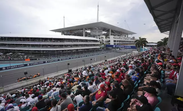 Fans watch McLaren driver Oscar Piastri of Australia race past during the Formula One Miami Grand Prix auto race Sunday, May 4, 2025, in Miami Gardens. Fla. (AP Photo/Rebecca Blackwell)