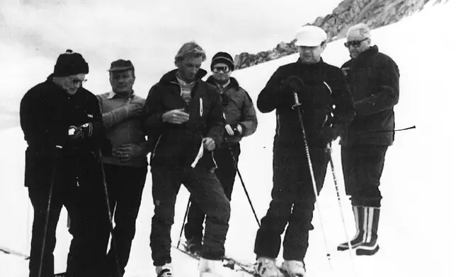 FILE - Pope John Paul II, left, joins other skiers in making the sign of the cross during his skiing vacation near this Northern Italian town, July 17, 1984. (AP Photo, File)