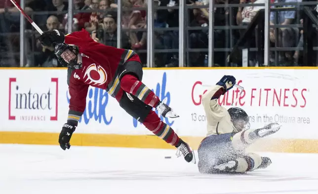 Ottawa Charge's Ashton Bell, left, goes airborne after colliding with Montreal Victoire's Marie-Philip Poulin, right, during first-period PWHL hockey playoff action in Ottawa, Ontario, Friday, May 16, 2025. (Spencer Colby/The Canadian Press via AP)